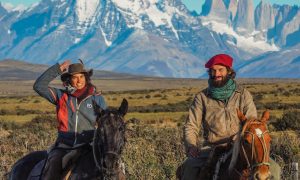 gaucho couple posing in horses in front of torres del paine national park